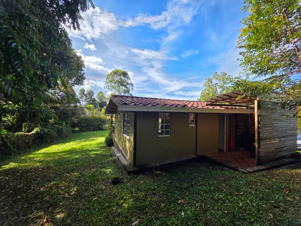Costado de la casa campestre con arquitectura tradicional, techo de teja de barro y lote privado cerrado de 1.500 m² pet friendly en Casa Campestre La Isabela, La Ceja